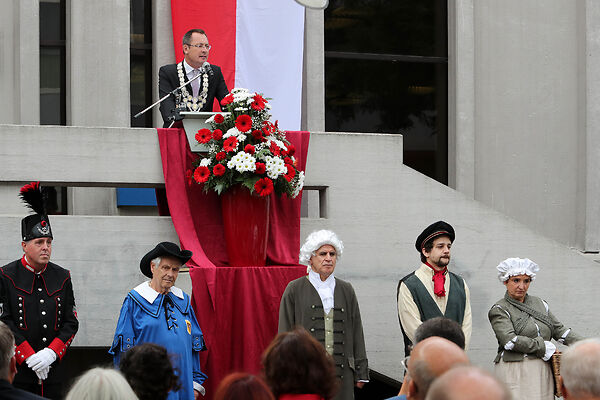 Auf dem Bild ist der damalige Oberbürgermeister Thilo Rentschler bei der Eröffnungsrede zu sehen. Unterhalb von ihm stehen einige in Gewändern verkleidete Personen.