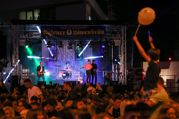 Auf dem Bild ist eine Band auf einer Bühne am Gmünder Torplatz zu sehen.