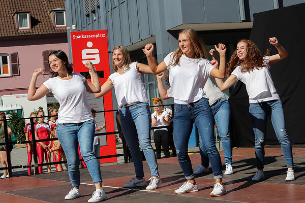 Auf dem Bild sind junge Frauen zu sehen, die auf dem Sparkassenplatz auf einer Bühne tanzen.