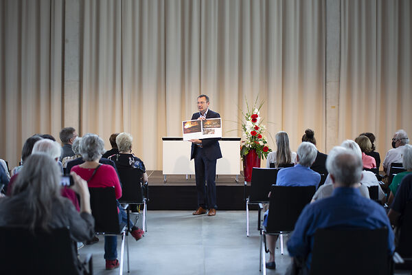 Auf dem Bild ist der OB a.D. zu sehen, der ein aufgeschlagenes Buch in den Händen hält.