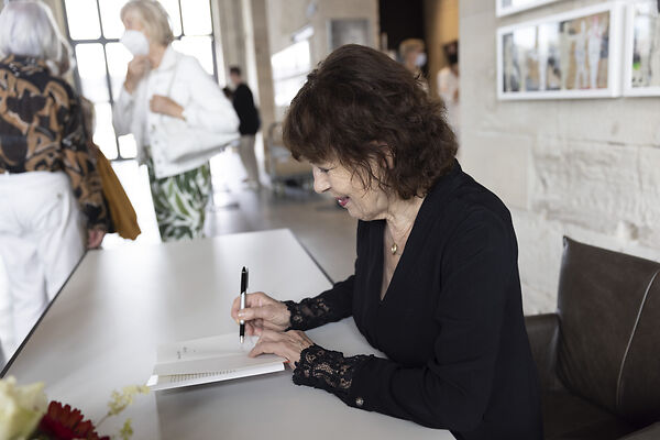 Auf dem Bild ist die Schubart-Literaturpreisträgerin zu sehen, die ein Buch signiert.