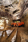 Auf dem Bild sind mehrere in Warnwesten gekleidete Personen zu sehen, die in einem Gang eines Bergwerks stehen.