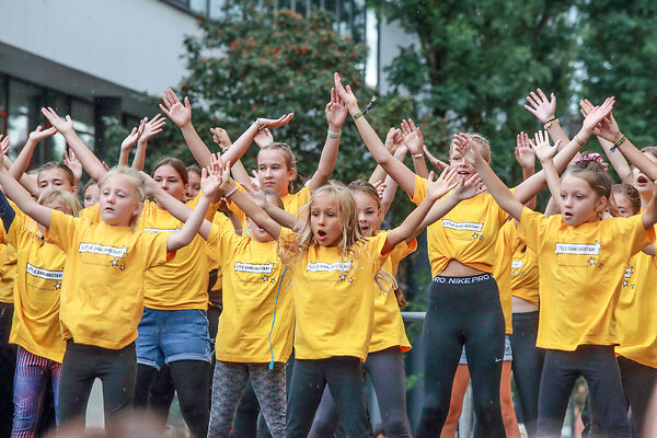 Auf dem Bild ist eine Sportgruppe in gelben Shirts zu sehen.