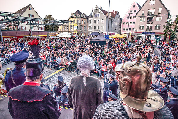 Auf dem Bild ist der ein Platz voller Menschen von oben fotografiert zu sehen.