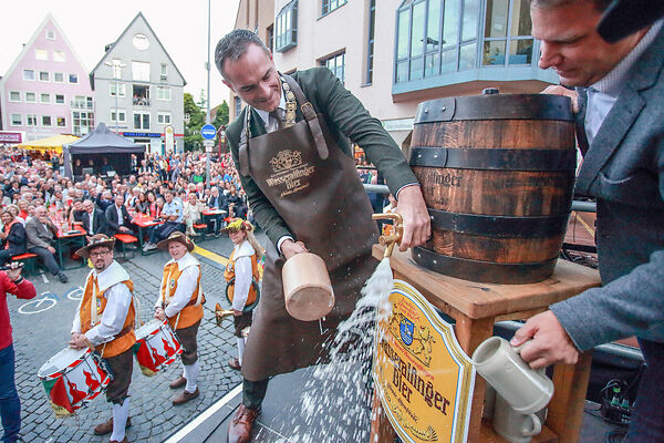 Auf dem Bild ist der Oberbürergermeister Brütting beim Fassanstich zu sehen.