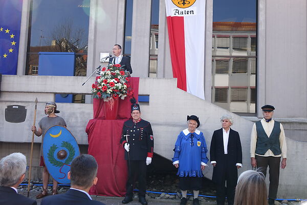 Auf dem Bild ist der damalige Oberbürgermeister Thilo Rentschler bei einer Rede vor dem Aalener Rathaus zu sehen. Vor ihm stehen einige in altertümlichen Kostümen gekleidete Herren.