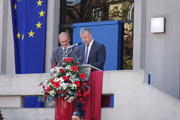 Auf dem Bild sind zwei Herren zu sehen, die vor dem Aalener Rathaus eine Rede halten.
