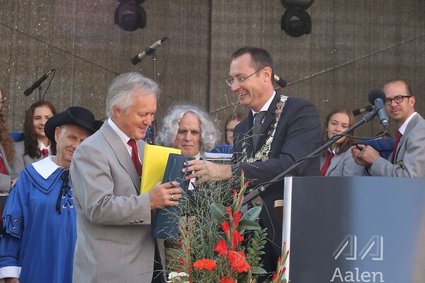 Auf dem Bild ist der damalige Oberbürgermeister Thilo Rentschler zu sehen, der einem anderen Herren Geschenke übergibt.