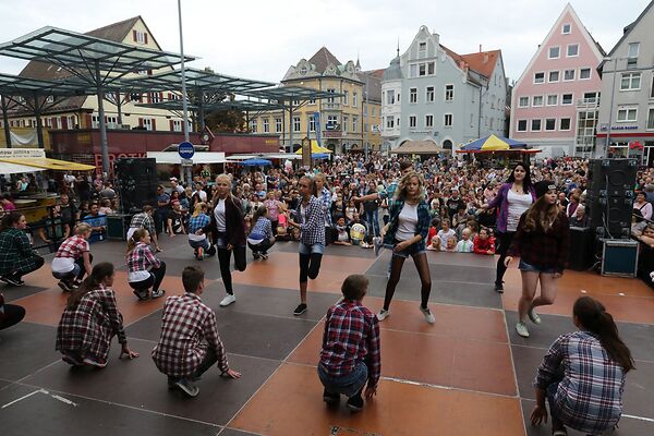 Auf dem Bild sind tanzende Kinder auf einer Bühne am Gmünder Torplatz zu sehen.