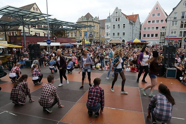 Auf dem Bild sind tanzende Kinder auf einer Bühne am Gmünder Torplatz zu sehen.
