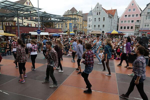 Auf dem Bild sind tanzende Kinder auf einer Bühne am Gmünder Torplatz zu sehen.