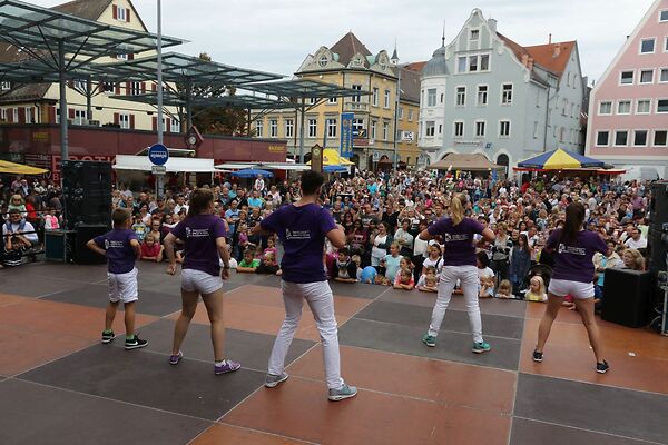 Auf dem Bild sind Tänzerinnen und Tänzer auf einer Bühne am Gmünder Torplatz zu sehen.