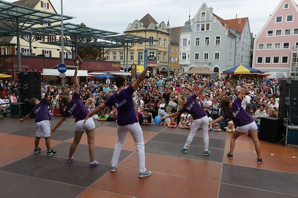 Auf dem Bild sind Tänzerinnen und Tänzer auf einer Bühne am Gmünder Torplatz zu sehen.