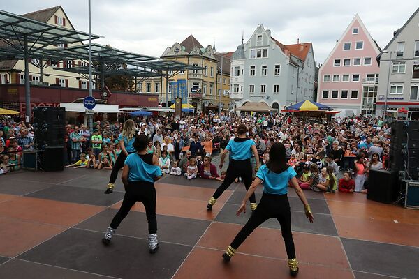 Auf dem Bild sind tanzende Frauen auf einer Bühne am Gmünder Torplatz zu sehen.