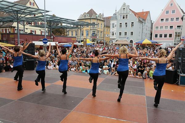Auf dem Bild sind tanzende Frauen auf einer Bühne am Gmünder Torplatz zu sehen.