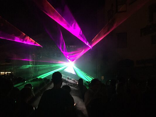 Auf dem Bild ist eine bunte Lasershow bei Nacht zu sehen.