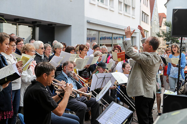 Auf dem Bild ist ein Chor mit einem Orchester zu sehen.