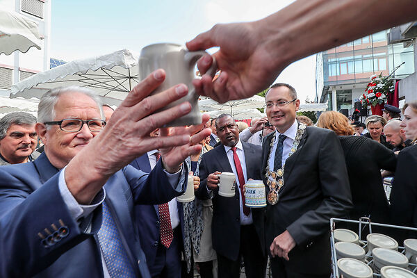 Auf dem Bild werden Bierkrüge ausgegeben.