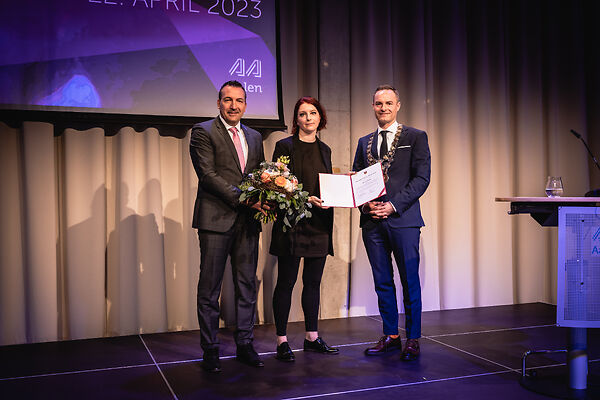 Auf dem Bild ist die Schubart-Förderpreisträgerin 2023 Slata Roschal, der OB Frederick Brütting und der Vorstand der KSK Ostalb Markus frei bei der Preisverleihung zu sehen.