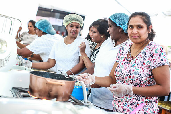 Auf dem Bild sind Frauen beim Kochen zu sehen.