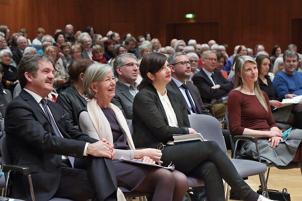 Auf dem Bild ist das auf Stühlen sitzende Publikum zu sehen.