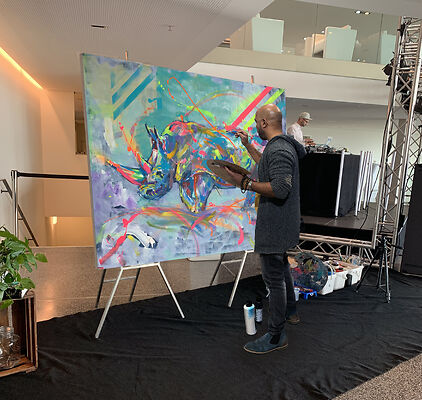 Auf dem Bild ist der Künstler Charles Castro beim Live-Painting zu sehen.