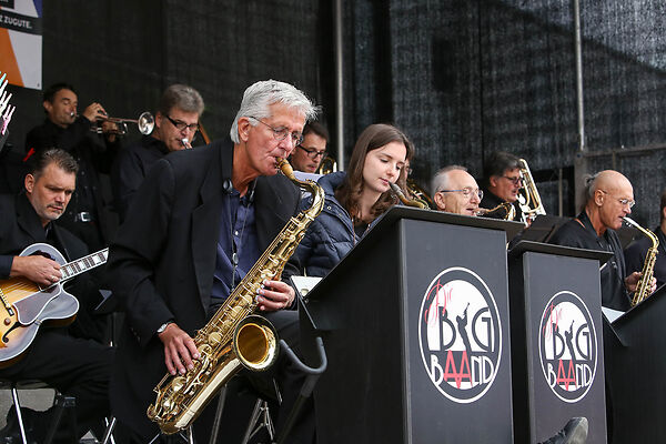 Auf dem Bild sind die Mitglieder der Aalener Big Band zu sehen, die auf einer Bühne musizieren.